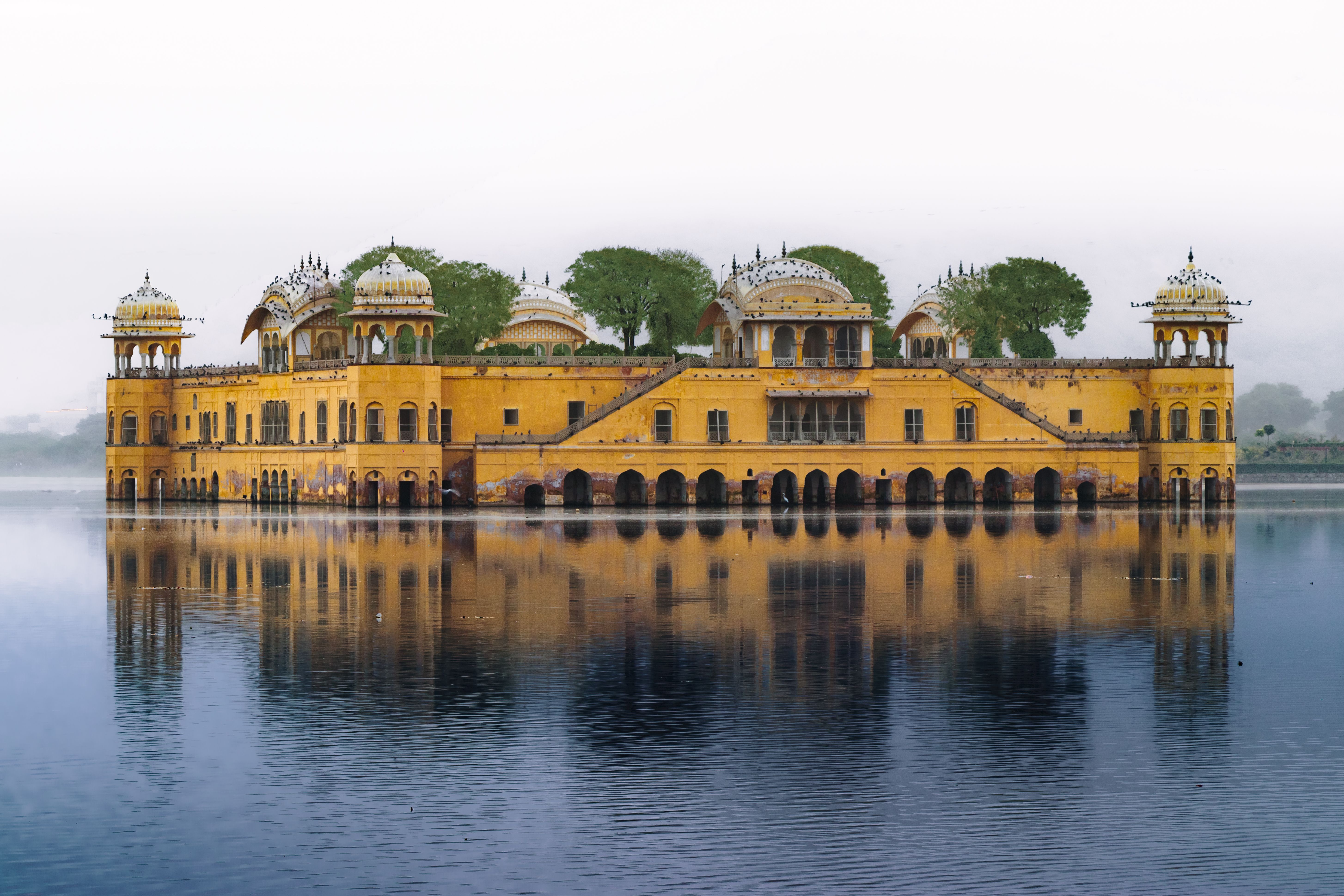 The Jal Mahal palace glowing at sunset amid the still waters of Man Sagar Lake